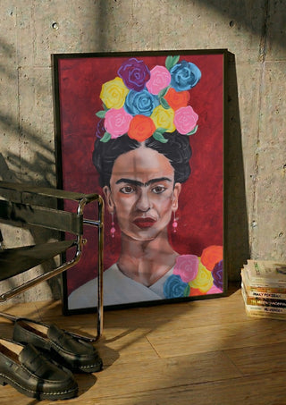 Frida Kahlo by creatievananne in a black frame leaning against a concrete wall by a steel chair