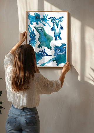 Creatures by Lena Galé being hung on a sunlit wall