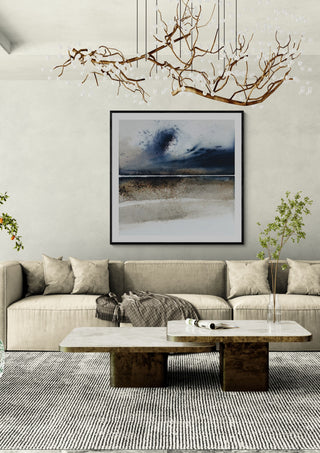 A wave from the past by Tania Zubareva in a black frame above a beige sofa under a branch chandelier