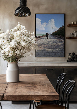 Departure and Return by Bora Kőhalmi in a black frame above a rustic table with white flowers