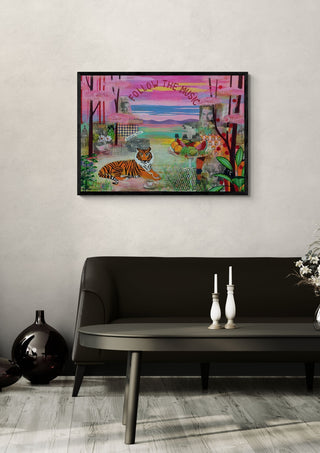 Follow the music by María Burgaz in a black frame on a pale wall above a dark sofa with candlesticks