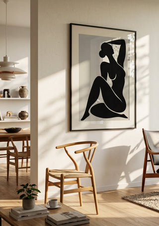 Abstract Black Nude Woman by TimlessArtworks in a black frame in a bright dining room with wooden chairs