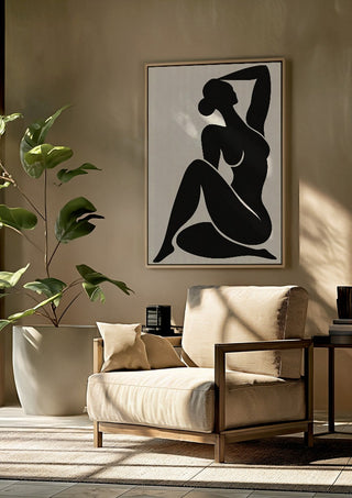 Abstract Black Nude Woman by TimlessArtworks framed above a beige armchair beside a potted plant