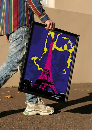 The Tower by Massimo Frascogna carried in a black frame along a sunny street