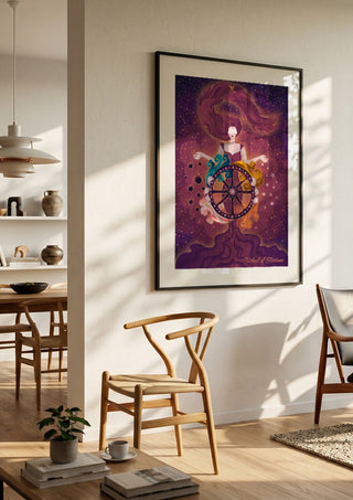 Wheel of Fortune by Sciurus tarotus in a black frame in a bright dining room with wooden chairs