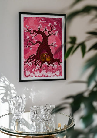 The Strength by Sciurus tarotus in a black frame above a glass table with crystal glassware