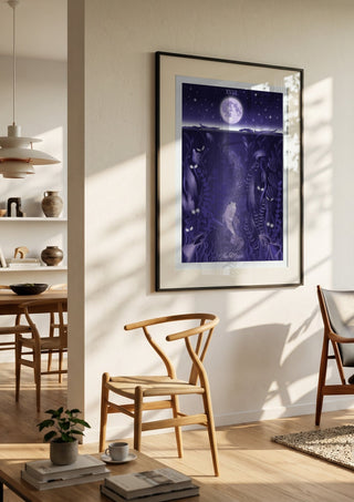 The Moon by Sciurus tarotus in a black frame in a bright dining room with wooden chairs