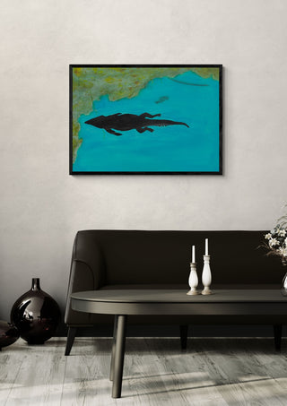 Crocodile swimming past by Sulaika Martis in a black frame on a pale wall above a dark sofa with candlesticks