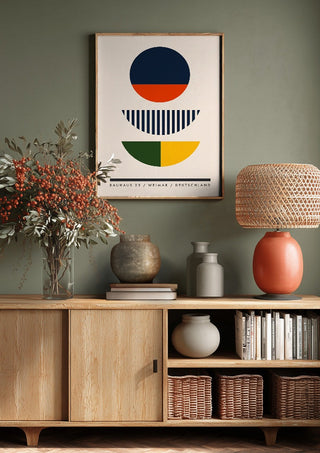 Bauhaus Circles by Neil Stevens above a wooden sideboard on a sage green wall