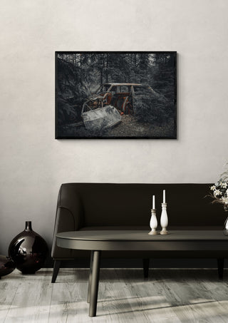 Decay (2) by Lone Gjessing in a black frame on a pale wall above a dark sofa with candlesticks