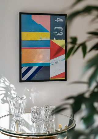 403 by Kareem Rizk in a black frame above a glass table with crystal glassware