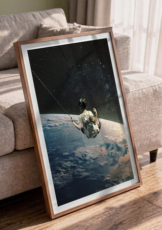 Swing by Fran Rodriguez in a walnut frame leaning against a grey sofa