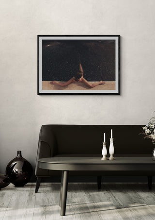 Holynight by Fran Rodriguez in a black frame above a dark sofa with candlesticks