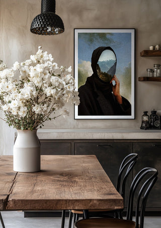 The Mountain Within by Fran Rodriguez in a black frame above a rustic table with white flowers