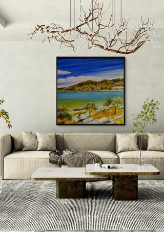 Dalmatia by Sunny in a black frame above a beige sofa under a branch chandelier