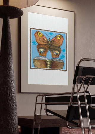 The Butterfly and the Book by Waldemar Mandzel framed in a dim room beside a tubular steel chair