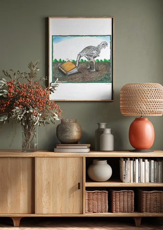 The Ostrich and the Book by Waldemar Mandzel above a wooden sideboard on a sage green wall