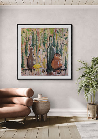 Summer mood by Dina in a black frame on a pale wall above a tan leather chair and a potted palm