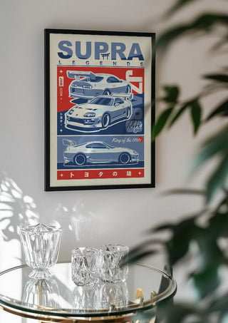 Toyota Supra MK4 by Kaminarirace in a black frame above a glass table with crystal glassware