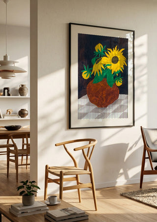 Gula blomster på rutig duk by Rebecka Hansson in a black frame in a bright dining room with wooden chairs