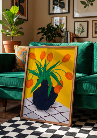 Orangea blomster i brun vas by Rebecka Hansson in a wooden frame leaning against a green velvet sofa on a chequered floor