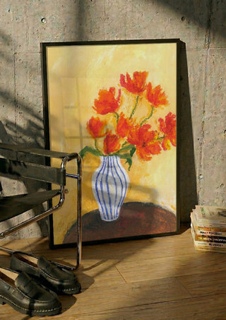 Tulips by Deblina Dey in a black frame leaning against a concrete wall by a steel chair