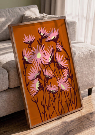 Whimsical flowers by Astrid Lind in a walnut frame leaning against a grey sofa