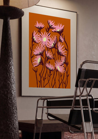 Whimsical flowers by Astrid Lind framed in a dim room beside a tubular steel chair