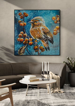 Bird on the autumn tree by Svetla Stoyanova Bassi in a black frame above a grey sofa with candlesticks