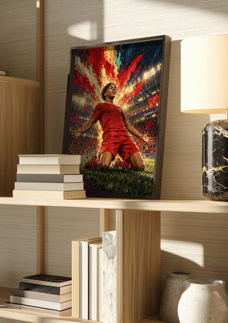 Rio Ngumoha Celebration by Danii Steinfeldt in a dark frame on a wooden shelf beside books and a lamp