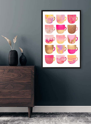 Framed print featuring various stylish pink coffee cup illustrations, displayed above a modern dresser.