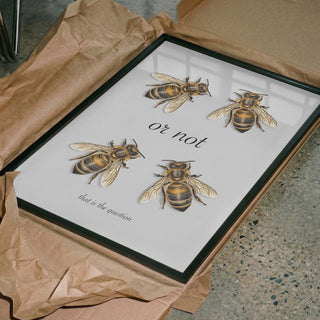 Framed "To Bee Or Not" Andreas Magnusson print featuring illustrations of bees and text, in a cardboard box.