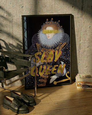 Framed "Slay Queen" portrait of Talitha McQueen leaning against a concrete wall, next to a chair and books.
