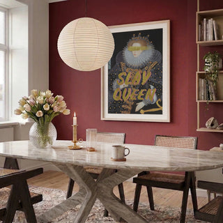Framed "Slay Queen" portrait by Talitha McQueen on a red wall in a modern dining room.