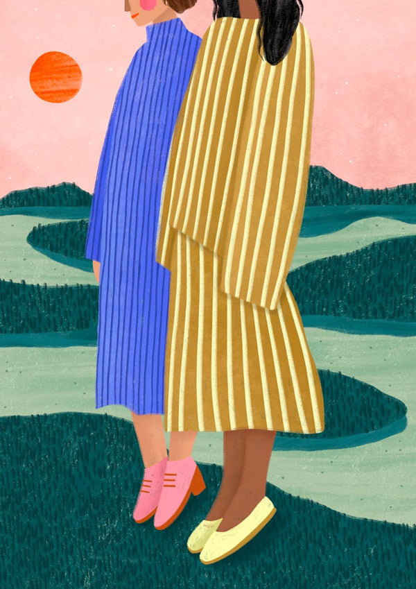 Two women in striped dresses stand together outdoors at sunset, one in blue, one in yellow.