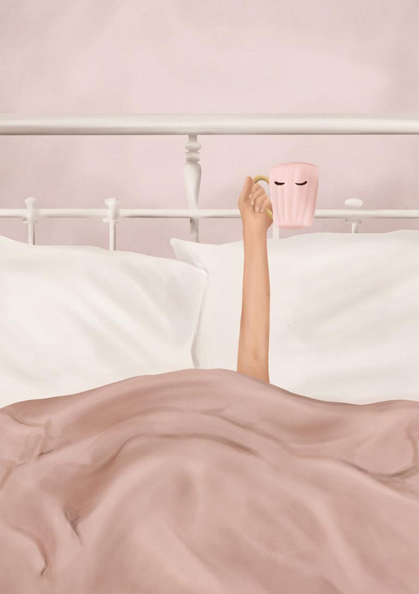 A person in bed lifts a pink Flow Line coffee cup with eyes design, surrounded by soft bedding.