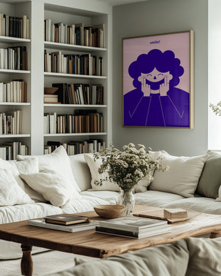 Framed "Big Happy Smile" by Monika Gregulska displayed above a sofa in a cozy, modern living room with bookshelves.