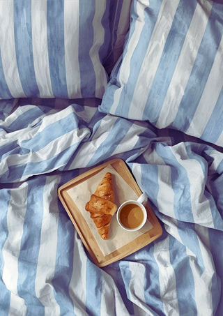 A Cozy Sunday in Bed by Ohkimiko - a breakfast tray on blue and white striped bedding