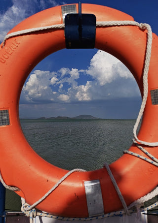 Three Layers of Presence by Bora Kőhalmi - an orange lifebuoy framing the green water and blue hills of Lake Balaton
