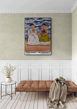 Poster of The Two Fridas by Frida Kahlo displayed above a bench in a modern, elegantly decorated room.