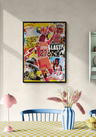 Framed artwork of Michael Jordan by Ricardo Noble on a wall above a table with flowers and decor.