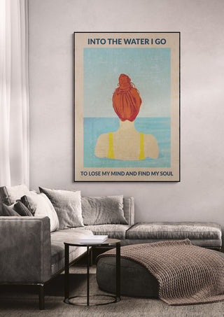 Wallchart featuring a woman with red hair facing water, text reads "Into the Water I Go" above a modern sofa.