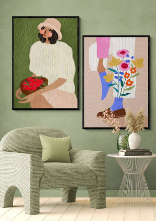 Framed art print of a woman in a hat holding strawberries, styled in a modern interior setting.