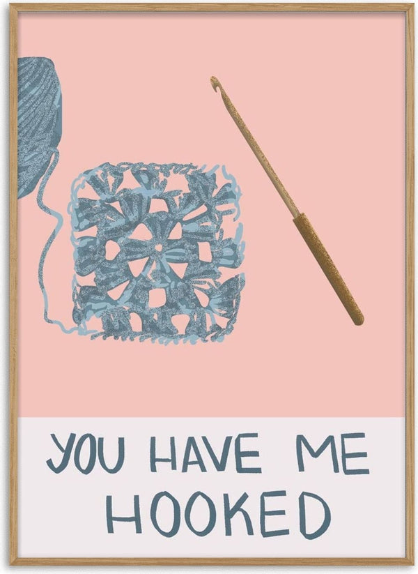 Illustration of yarn, a crochet hook, a crocheted square, and the phrase “You have me hooked.”