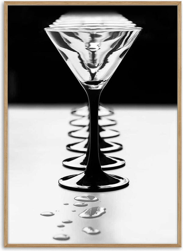 A line of elegant Giorgio Toniolo goblets with reflections and water droplets on a smooth surface.