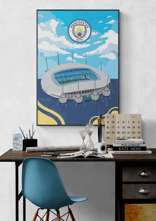 City of Manchester Stadium football poster hanging above a desk in a modern workspace.
